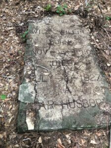 Cracked slab marker with engraved names and dates