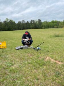 Man setting up drone in open field